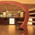 Lotos Inn & Suites, Nairobi: modern lobby bar with red circular frame and tables