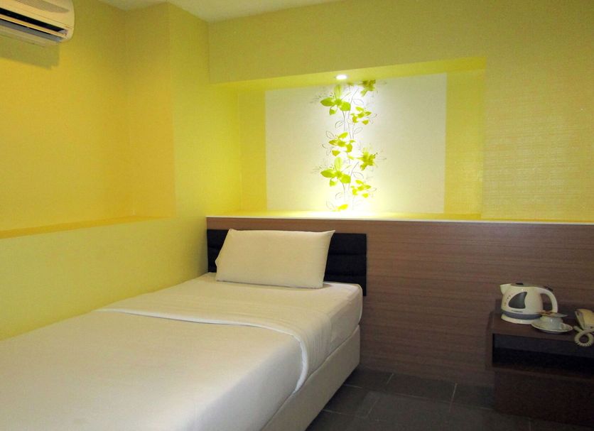 T-Hotel Bukit Bintang in Kuala Lumpur room with a single bed, bedside table and wall-mounted air conditioner