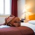 Hotelli Ville Tampere guest room with bed, leather duffel bag, lamp, and window with curtains