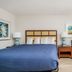 Extended Stay Suites Cookeville guest room with king bed, chair, and bedside table