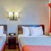 Motel 6 Santa Rosa Nm room with two beds, bedside table, and wall sconce in Santa Rosa.