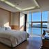 Benikea Hotel Yeosu guest room with king bed and ocean view through floor-to-ceiling windows