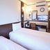 Toyoko Inn Narita Airport Honkan room with twin beds, desk, mirror and wall-mounted TV in Narita