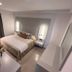 Theoxenia Caldera Hotel in Thera: modern guest room with queen bed, desk, and sliding window curtains