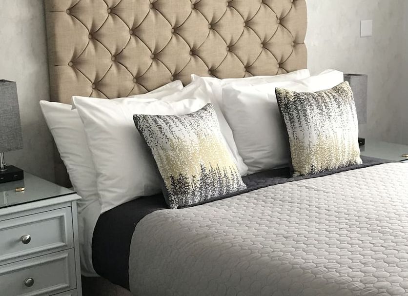 The Old School House Rooms Cambridge bed with tufted headboard and patterned accent pillows