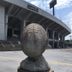 Smile Hotel Kumagaya exterior with a large stone sculpture in front of the stadium-like building in Kumagaya