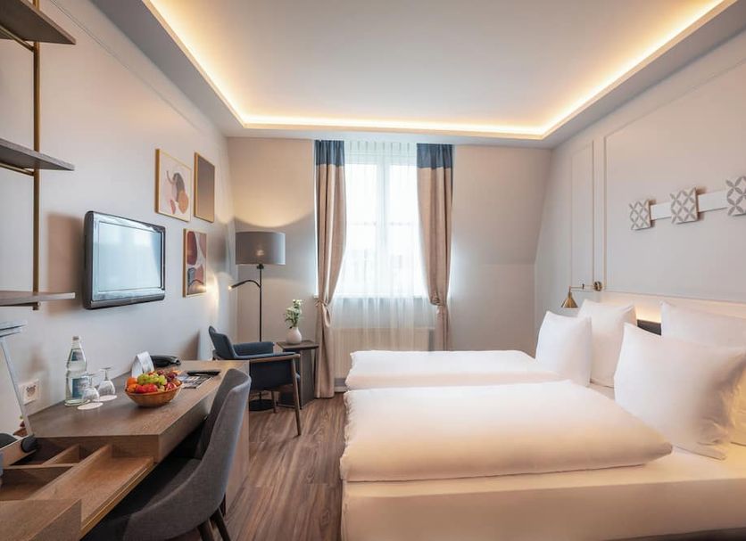 Seetelhotel Pommerscher Hof in Heringsdorf guest room with twin beds, desk, TV, and window seating