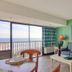 Peppertree by the Sea in North Myrtle Beach with ocean-view balcony, blue sofa, and bright living area
