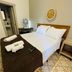 Hospedagem Central in Tiradentes bedroom with bed, patterned tile floor, and folded towels