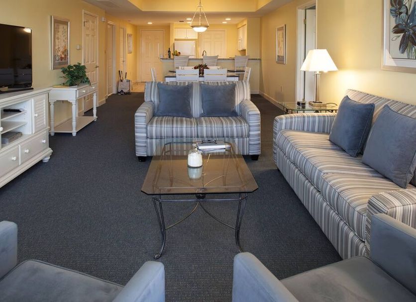 Waterside by Spinnaker Resorts living room with striped sofas, TV, coffee table and kitchen in Hilton Head Island
