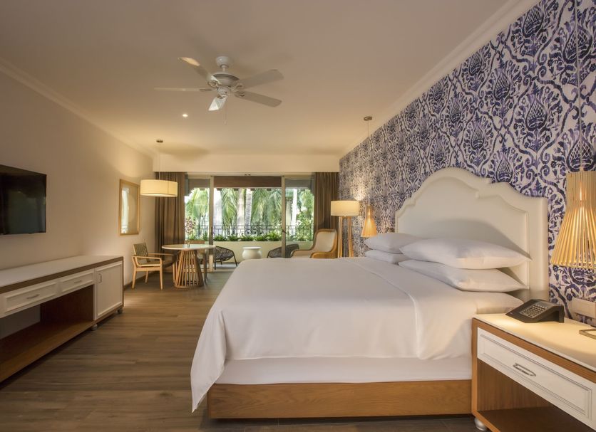 The Hacienda at Krystal Grand Puerto Vallarta guest room with king bed, balcony view, and blue patterned accent wall