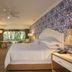 The Hacienda at Krystal Grand Puerto Vallarta guest room with king bed, balcony view, and blue patterned accent wall