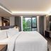 Gardina Asoke Hotel & Residence in Bangkok bedroom with large bed, wall-mounted TV and city-view window