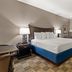 Americas Best Value Inn Byhalia guest room with king bed, desk, lamp, window bench and carpeted floor