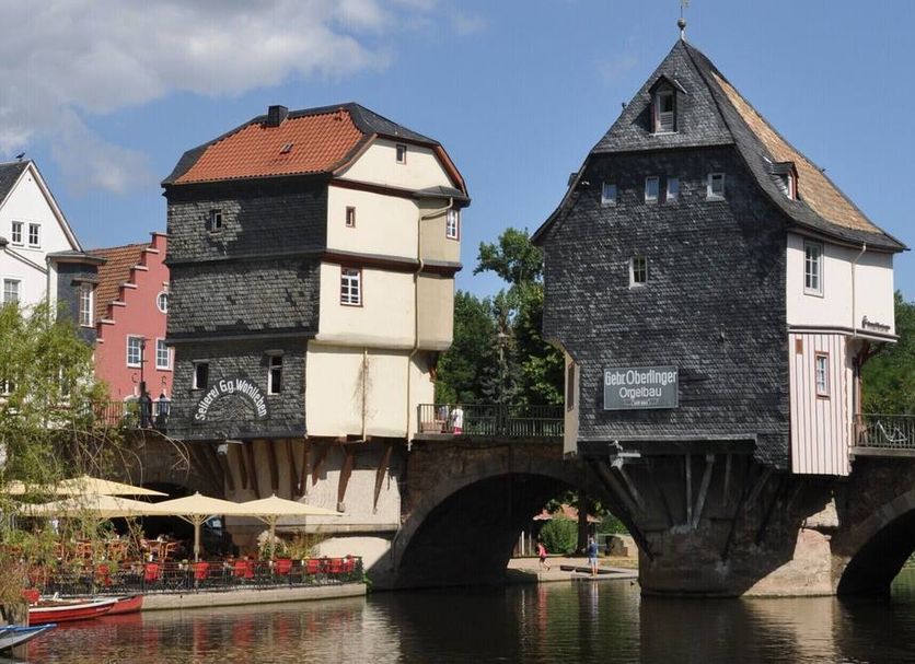 Zur Rotenfelsstube in Norheim, riverside hotel beside a stone bridge and calm water under a blue sky
