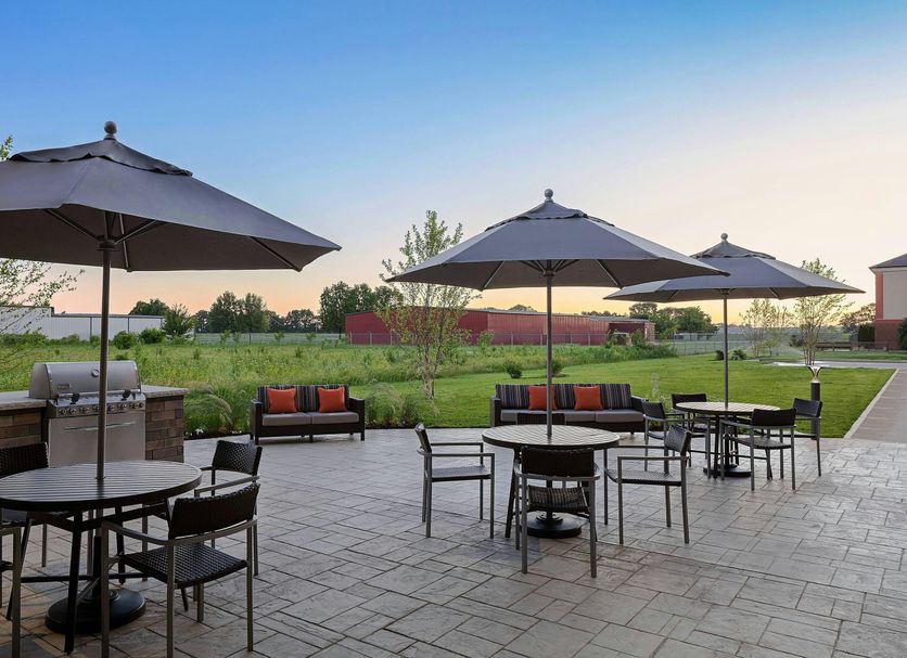 Towneplace Suites By Marriott Danville patio with tables, umbrellas and outdoor grill overlooking green lawn