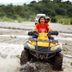 Bognot Lodge Mt Pinatubo Guesthouse in San Jose: guests riding an ATV through a shallow river