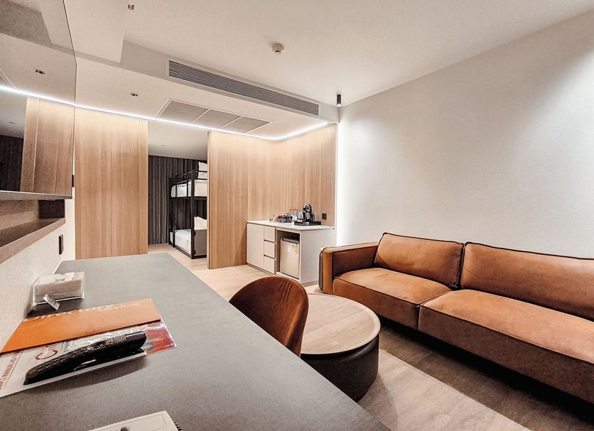 Citrus Sukhumvit 13 Nana Bangkok by Compass Hospitality room with sofa, desk, and kitchenette area