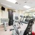 Berkley Lake Townhomes in Kissimmee fitness room with treadmill, stationary bike, mirrors, and ceiling fans