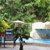 Hotel Arenas del Pacifico in La Crucecita with poolside chairs, umbrellas, and a waterfall-style pool