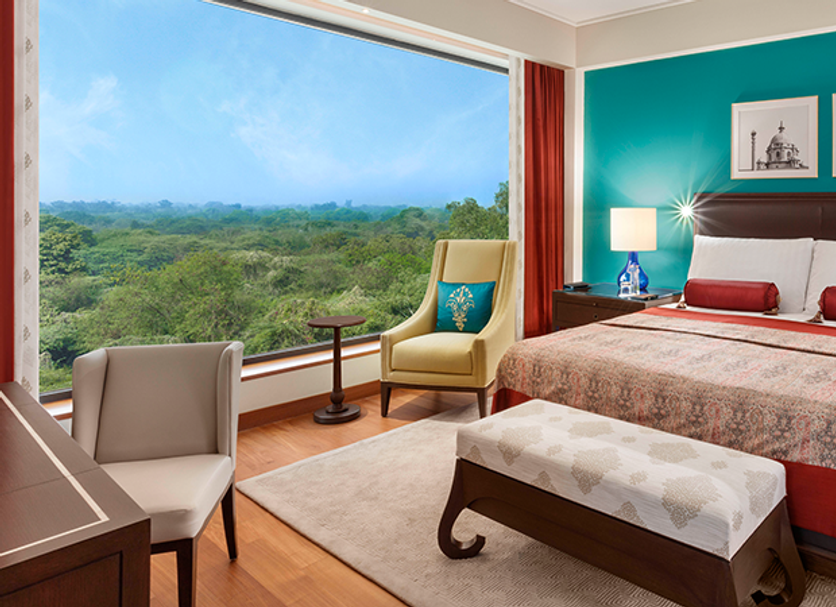 The Oberoi New Delhi room with king bed and large window overlooking lush greenery in New Delhi