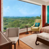 The Oberoi New Delhi room with king bed and large window overlooking lush greenery in New Delhi