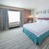 Hilton Garden Inn Clifton Park guest room with king bed, window view, and bedside lamps