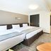 Richmond Hotel Higashi Osaka room with three beds, desk, and hallway in Higashiosaka