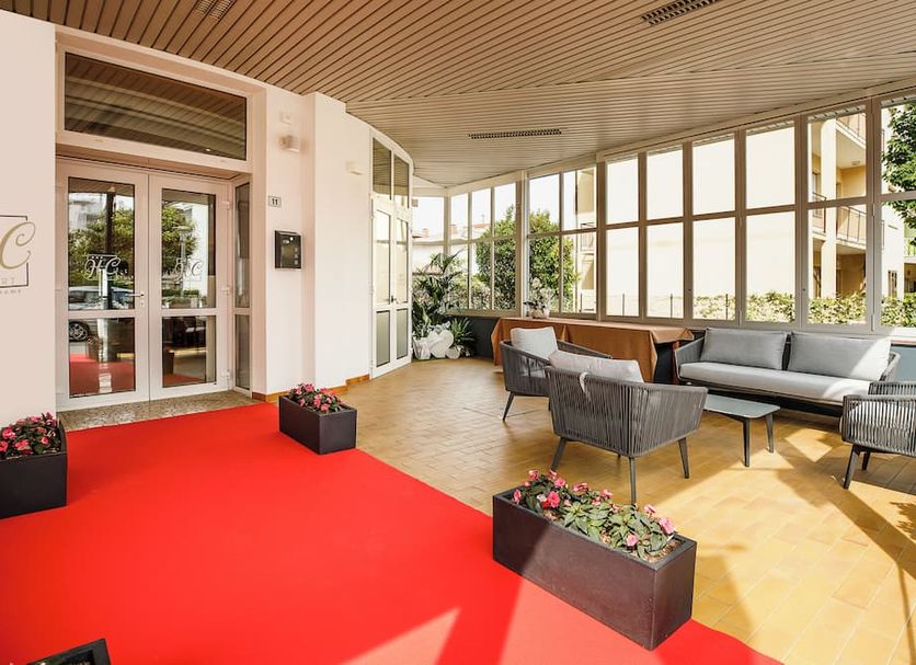 HC Resort, Lignano Sabbiadoro lobby with red carpet, lounge seating and large windows