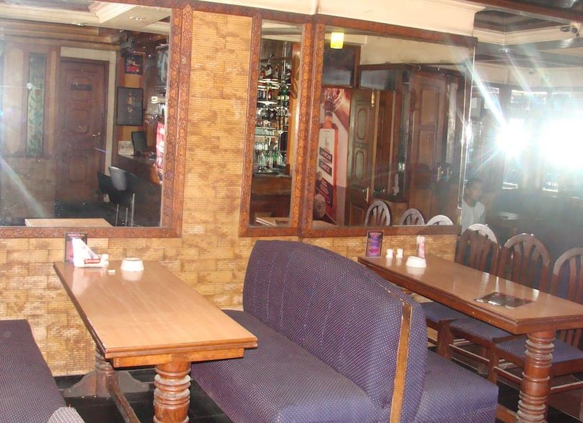 Hotel Abhinandan Grand, Dehradun: cozy restaurant seating with wooden tables and booths
