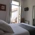 Hôtel En Ville in Aix-en-Provence room with bed, wall-mounted TV, mirror and open balcony doors