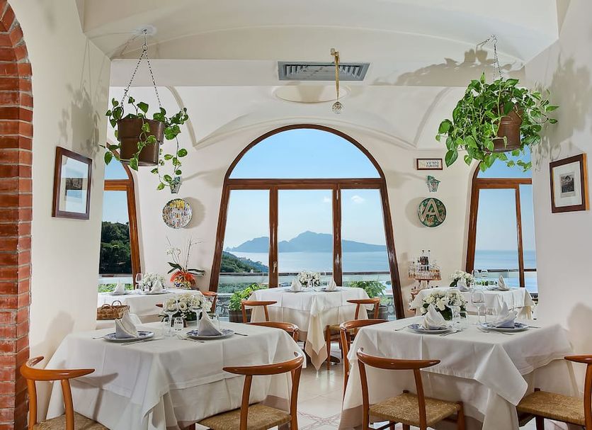 Hotel & Spa Bellavista Francischiello dining room with arched windows and sea view in Massa Lubrense
