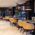 Leonardo Hotel Madrid City Center lounge with mustard chairs, blue banquette seating and shelving