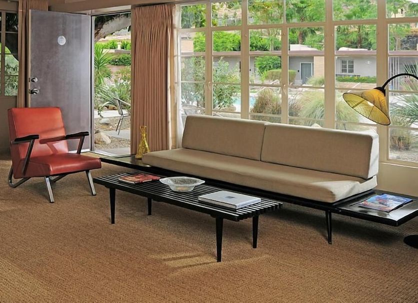 The Hideaway in Palm Springs living room with large windows, sofa, coffee table and lounge chair