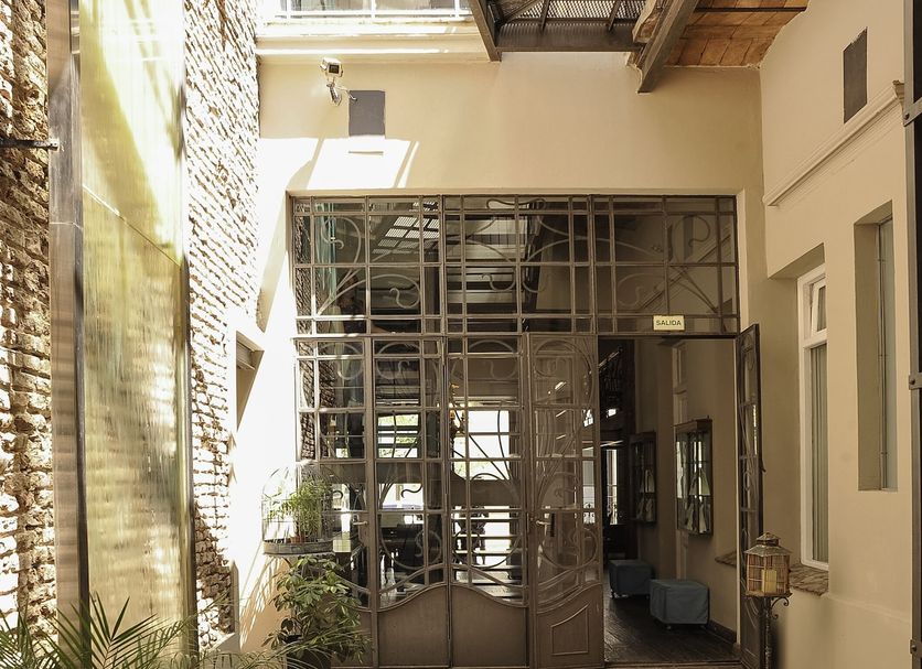 San Telmo Luxury Suites in Buenos Aires courtyard with skylight, glass doors, and potted plants