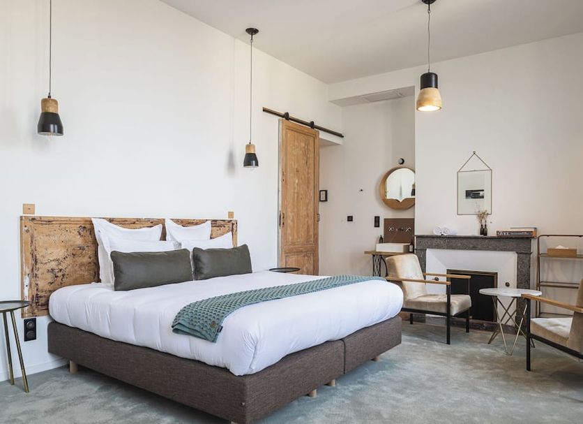 Casa Blanca B&B Bordeaux room with king bed, fireplace, seating area and pendant lights