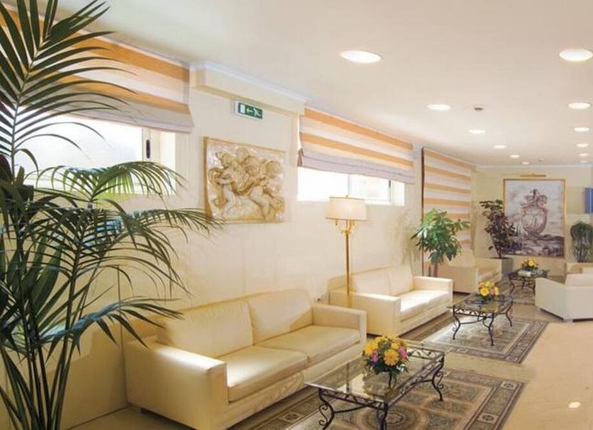Hotel Orizzonte in Letojanni lounge with cream sofas, glass coffee tables and potted plants