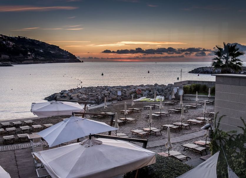 Hotel Riviera dei Fiori in San Lorenzo al Mare with seaside terrace, loungers, umbrellas and sunset bay view