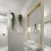 Monument Hotel Athens bathroom with gold-framed mirror, floating sink and shower, plus hanging greenery
