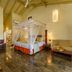Siddhalepa Ayurveda Resort in Molligoda room with canopy bed, sofa, and polished floor