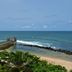 Pestana São Tomé oceanfront view with a wooden pier, sandy beach, and tropical greenery in São Tomé
