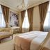 Galata Antique Hotel Istanbul room with canopy bed, tufted chaise lounge, and tall curtains