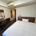 Hotel Route-Inn Nagoya Sakae guest room with bed, desk, mirror, and wall-mounted air conditioner in Nagoya