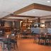 Quality Inn Perrysburg lobby seating area with tables, chairs, and a bar counter