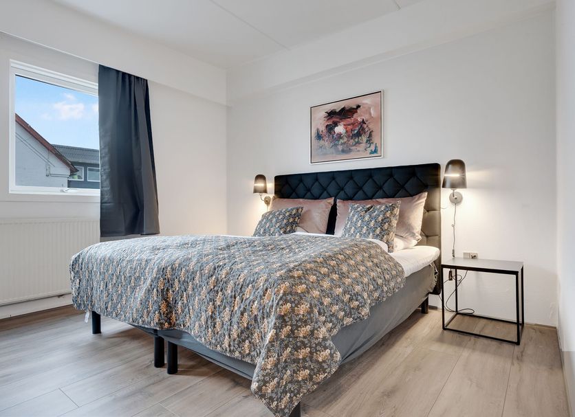 Hotel Hjallerup Kro bedroom in Hjallerup with a double bed, bedside lamps and window light.