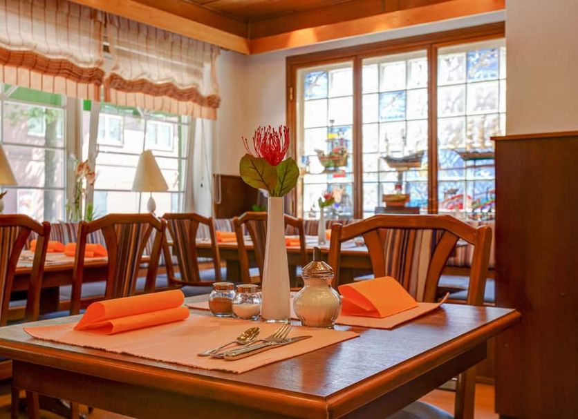 Hotel Elbinsel Hamburg dining room with set wooden tables and large windows