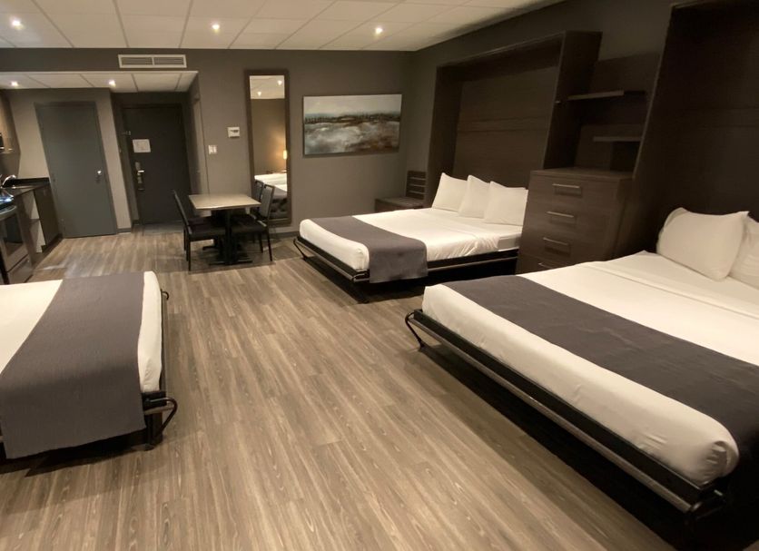 Hotel & Suites Le Dauphin Drummondville room with three beds and kitchenette in Drummondville