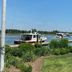 Tilghman Island Inn in Tilghman Island with marina boats, docks, and waterfront lawn under a clear sky.