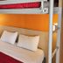 Premiere Classe Strasbourg Ouest compact room with bunk bed over double bed and orange wall