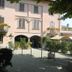 Albergo Michieletto in Montano Lucino, pink hotel facade with arched entrance and tree-shaded courtyard